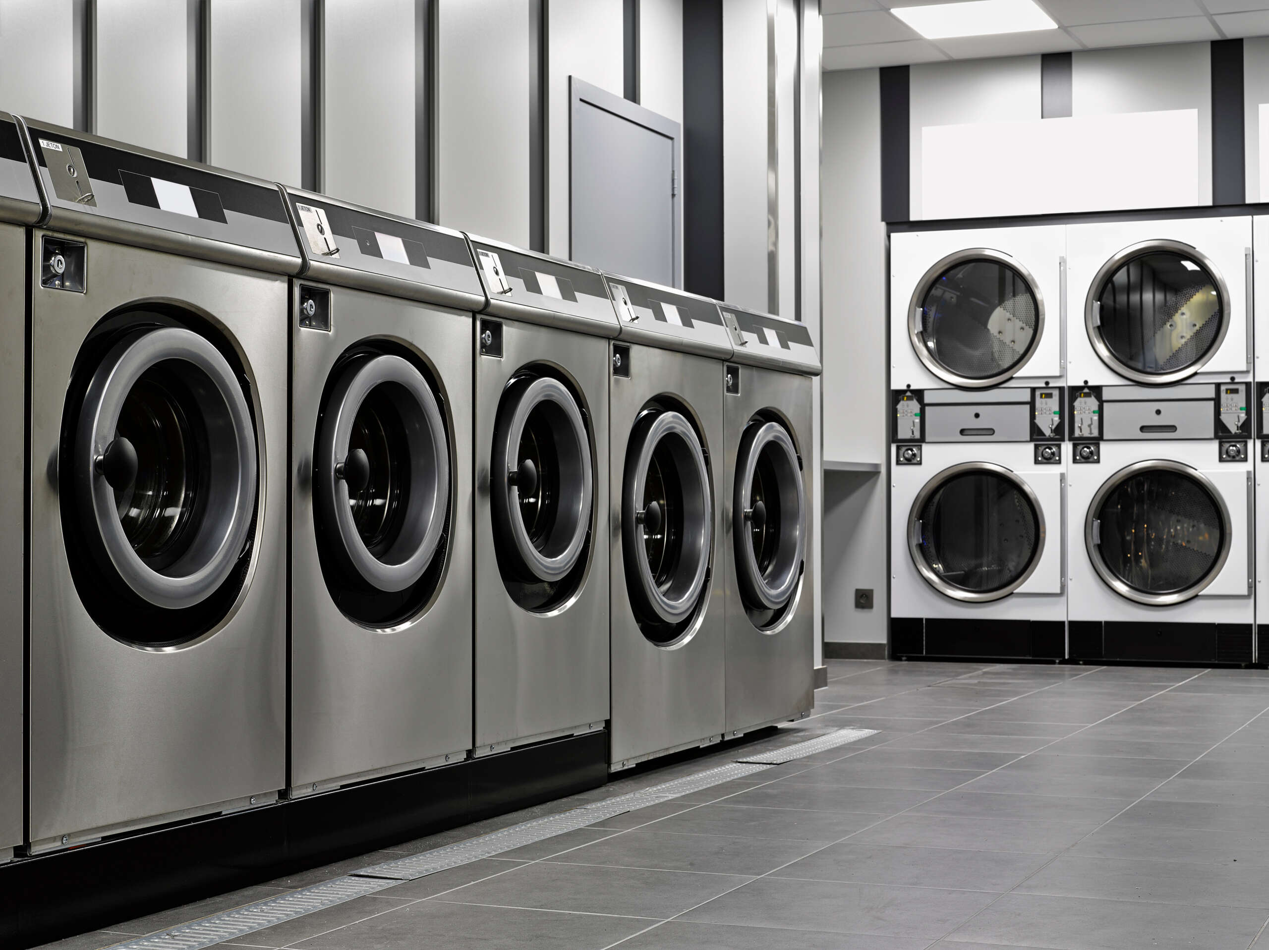 Laundromat Business Name Ideas: A row of industrial washing machines in a public laundromat
