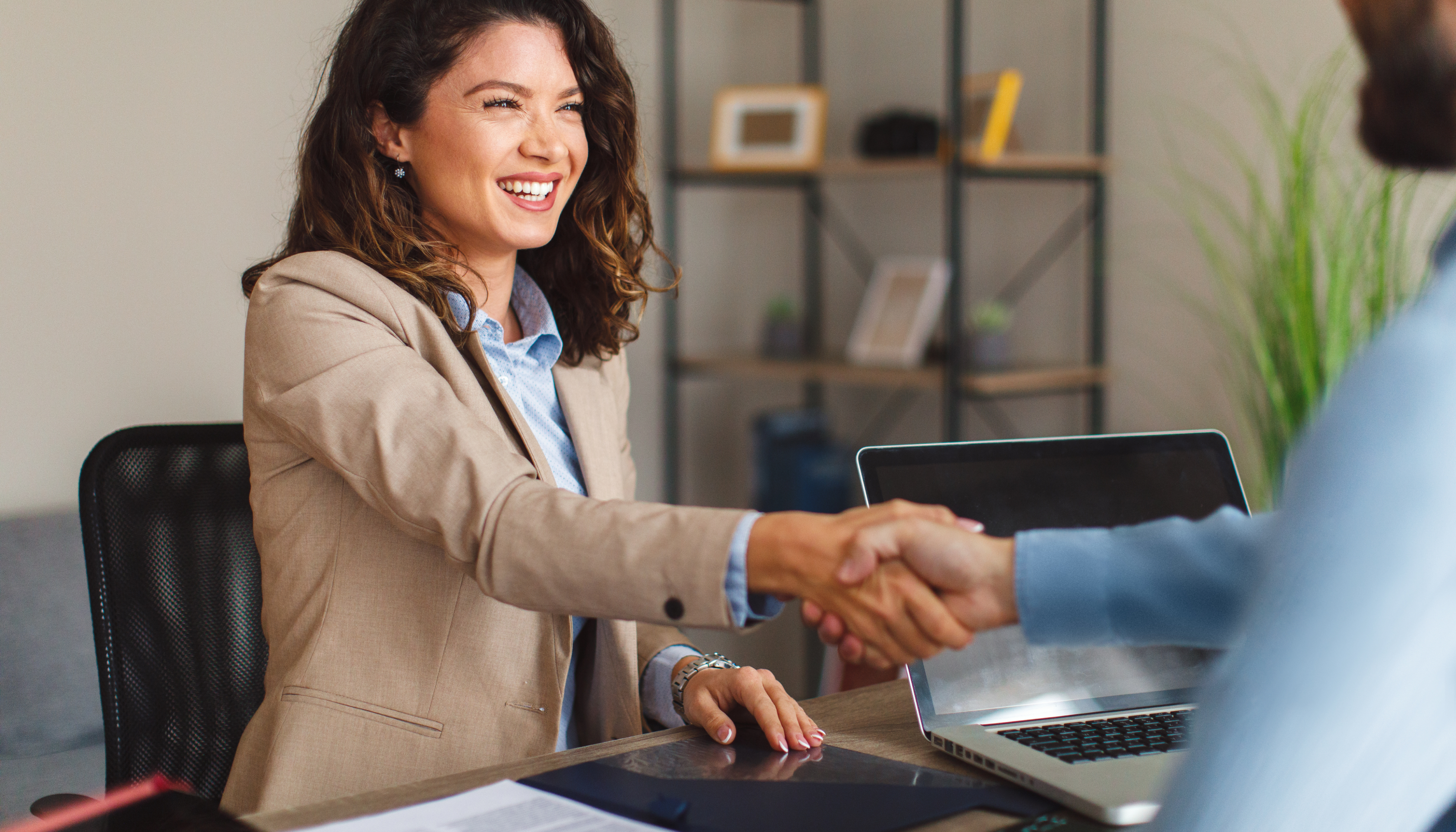 What Is a Business Operating Agreement?: An image of a smiling businesswoman shaking a man's hand.